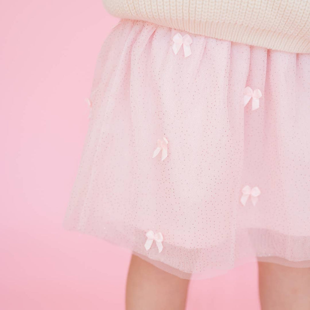 Pink skirt with bow details on a pink background