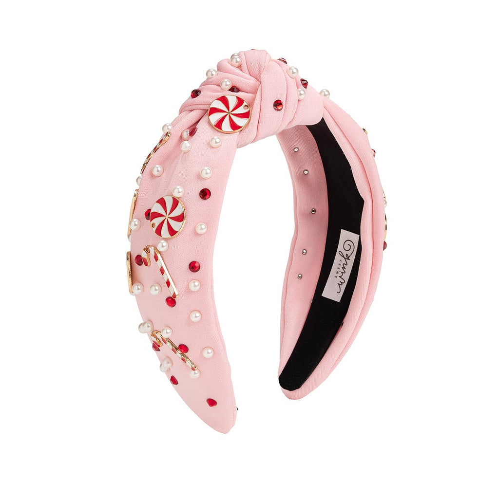 Pink decorative headband with candy cane designs on a white background