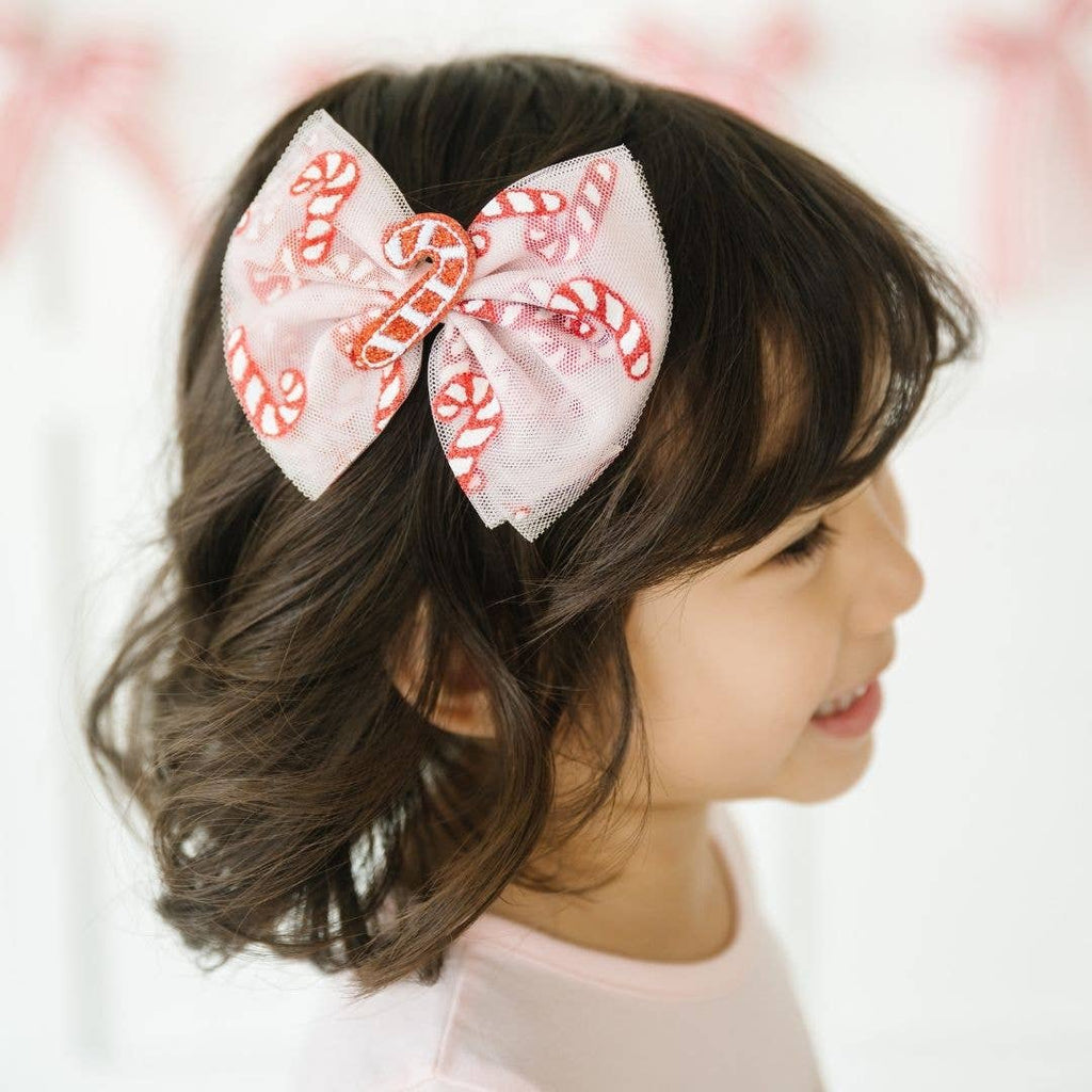 Child with a large decorative hair bow on a blurred background