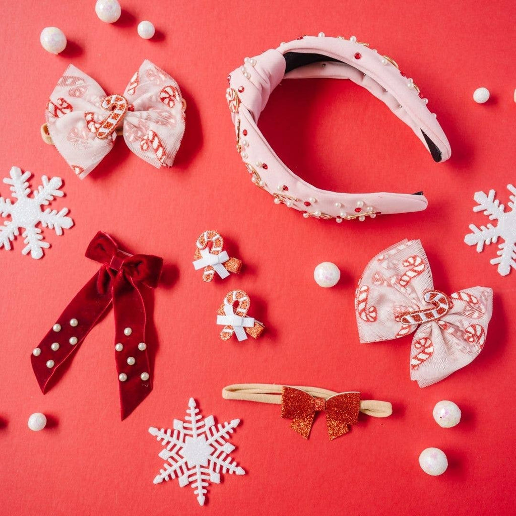 Decorative hair accessories including bows and a headband on a red background with snowflakes.