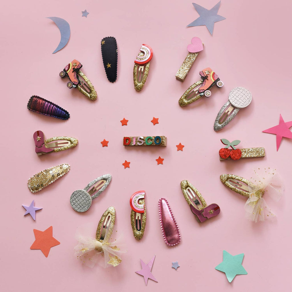 Colorful hair clips arranged on a pink background with decorative stars.