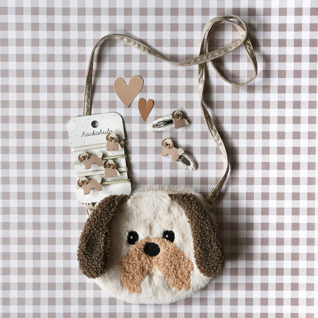 Dog-shaped pouch with a leash and heart-shaped earrings on a checkered background