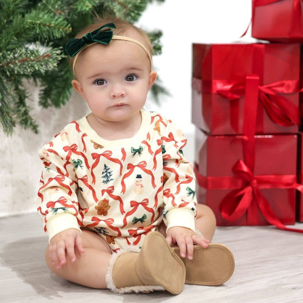 Baby in a festive outfit with Christmas decorations and presents