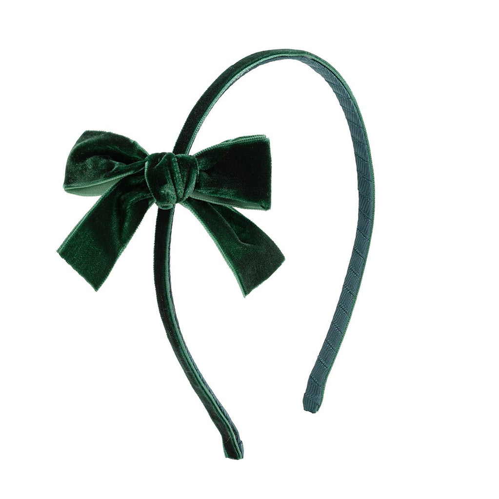 Green velvet bow headband on a white background