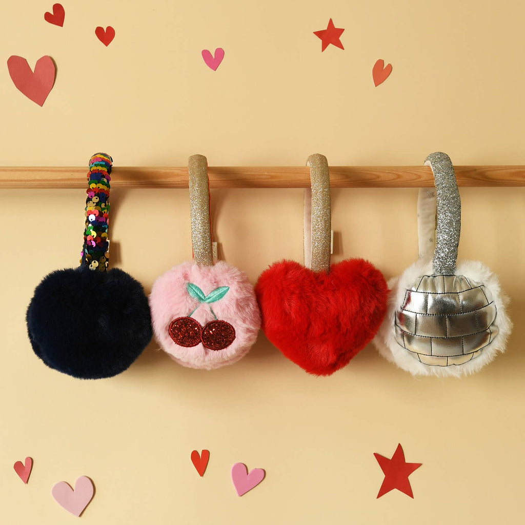 Four plush keychains on a wooden rod with decorative hearts and stars on a beige background.
