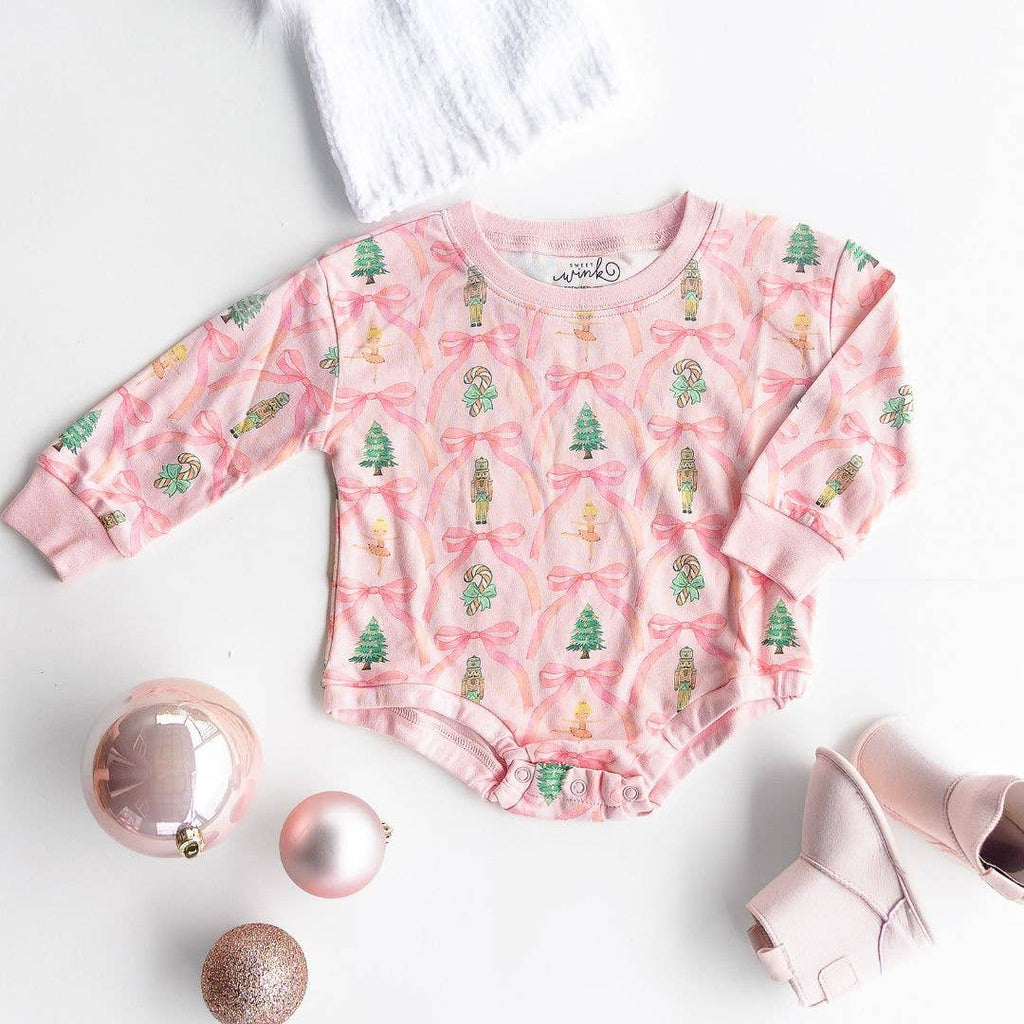 Pink baby romper with Christmas tree pattern on a white background