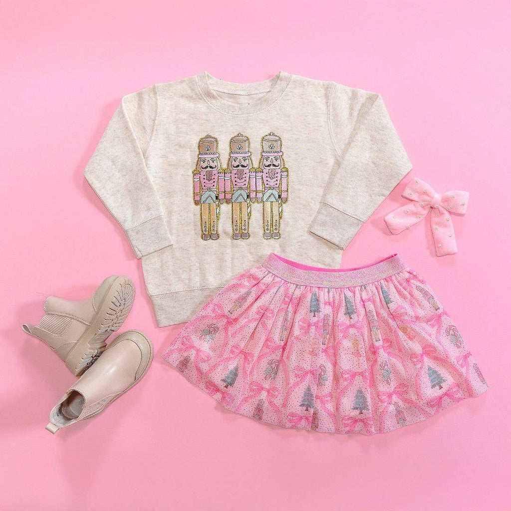 Children's outfit with sweater and skirt on a pink background