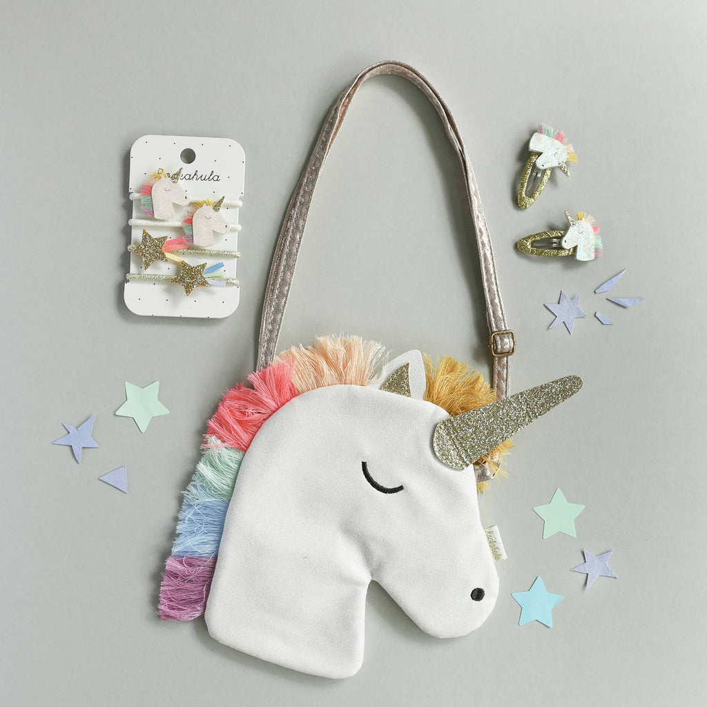 Unicorn-shaped bag with rainbow hair and gold horn on a gray background