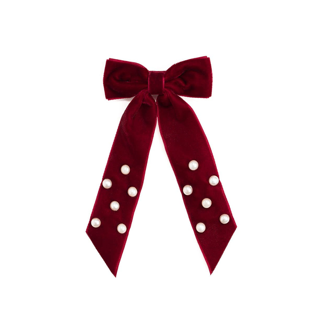 Red velvet bow with white polka dots on a white background