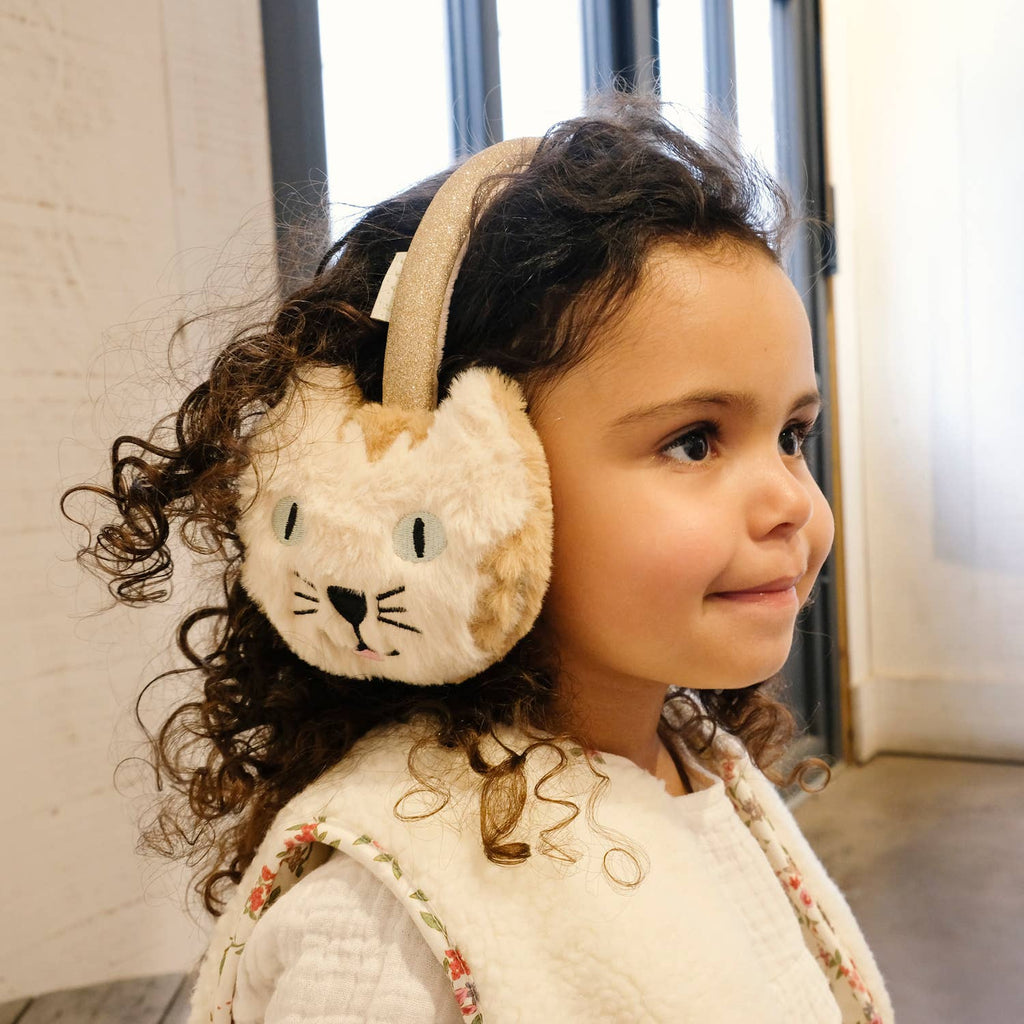 Child wearing a fluffy animal-themed ear muff with a neutral background